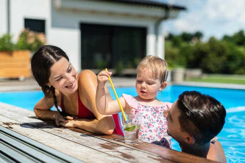 A family enjoying a Backyard with a pool