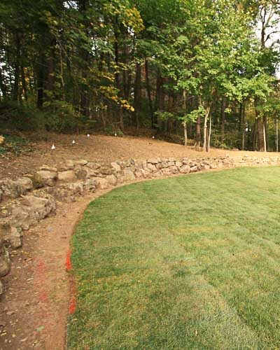 Backyard landscape renovation using boulders, sod, grading