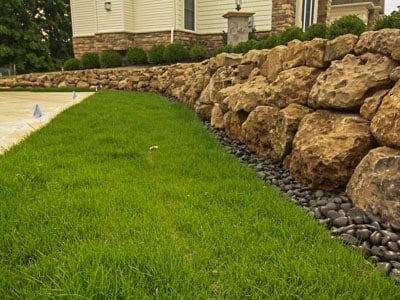 Boulder retaining wall and backyard landscaping