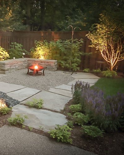 Backyard landscaping, natural stone, firepit, stone wall, landscape lighting