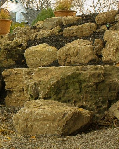Boulder wall in a backyard in Greece NY