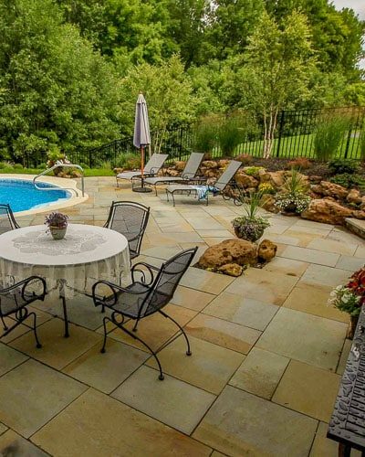 Boulder retaining wall used to retain grade change for inground pool in Rochester NY